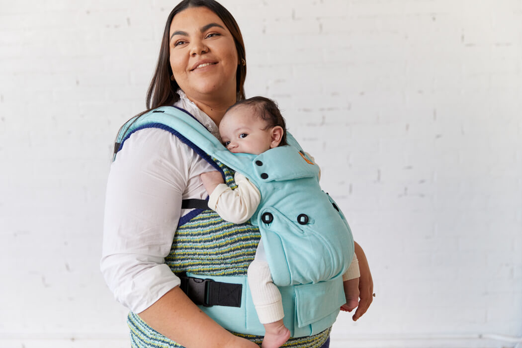 Mama nosi malutkie dziecko w pozycji przodem do rodzica w nosidełku Tula Linen Explore Robin