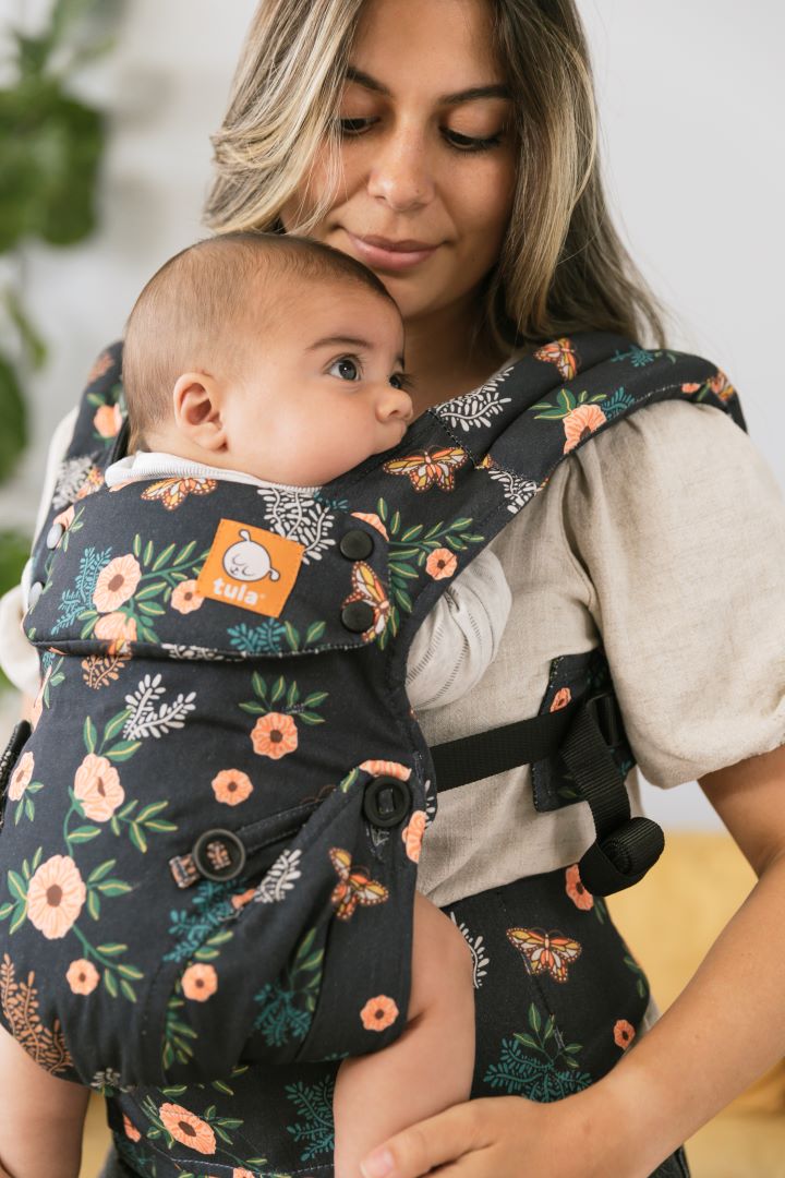 Usmiechnięta mama z niemowlakiem w ergonomicznej pozycji w Nosidełku Tula Explore Botanical
