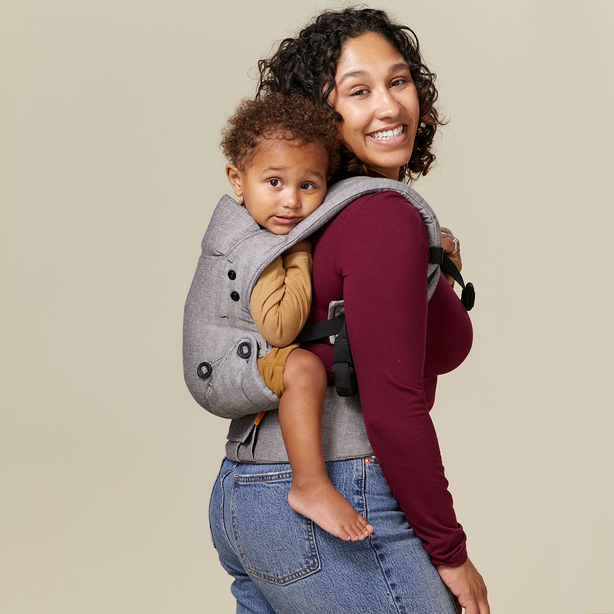 Mama nosi swoje dziecko na plecach w nosidełku Tula Explore