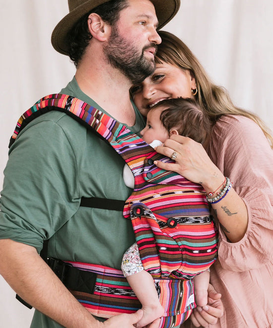 Rodzice tulą dziecko noszone przez tatę w nosidełku Tula Explore z kolekcji Signature
