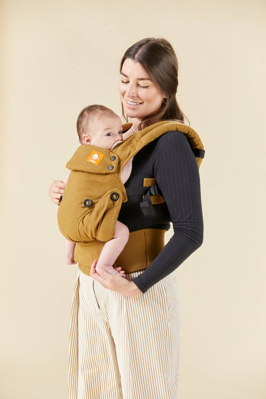 Uśmiechnięta mama nosi w ergonomicznym nosidełku Tula Explore Hemp z konopi.