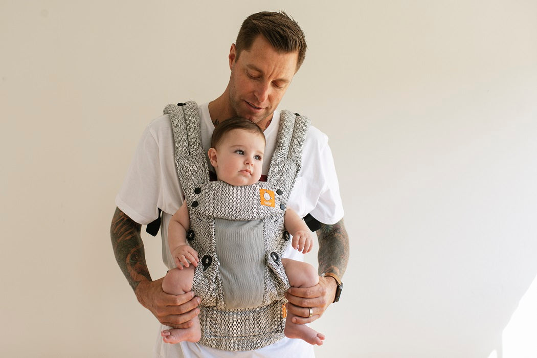 Tata nosi dziecko w pozycji przodem do świata w nosidełku Tula Explore Coast Infinite 