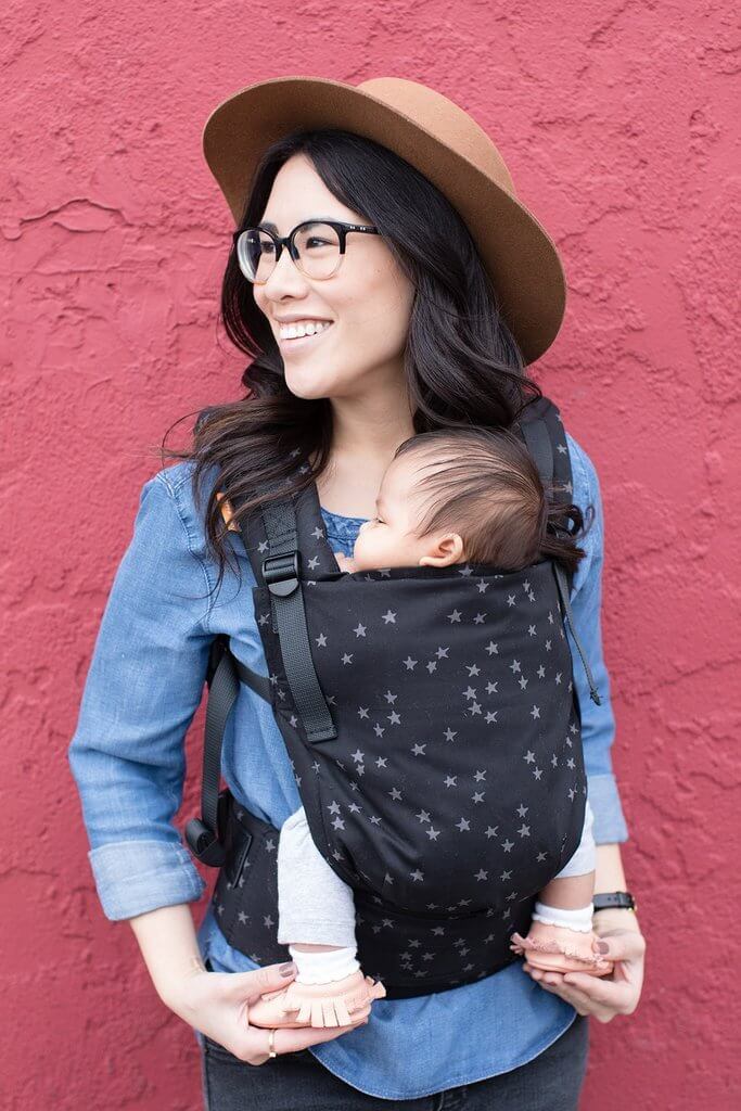 Mama nosi małe dziecko w pozycji przodem do rodzica w nosidełku Tula Free-to-Grow