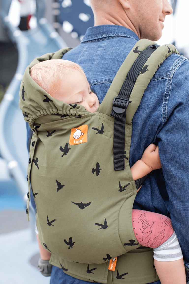 Tata nosi dziecko w pozycji na plecach w nosidełku Tula Free-to-Grow