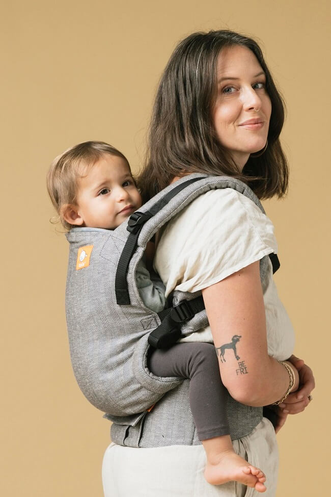 Mama nosi dziecko na plecach w nosidełkuTula Linen Free-to-Grow Ash