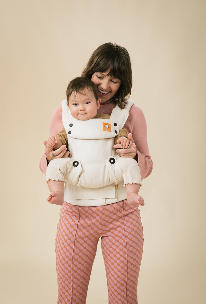 Mama nosi niemowlaka w pozycji przodem do świata w nosidełku Tula Linen Explore