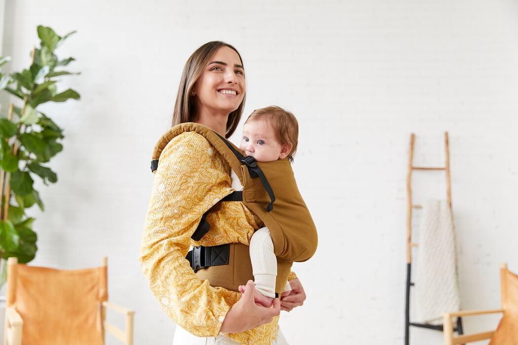 Mama nosi niemowlaka w nosidełku Tula Free-to-Grow w pozycji serce do serca