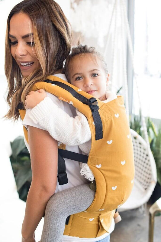 Mama nosi dziecko w nosidełku Tula Free-to-Grow w pozycji na plecach
