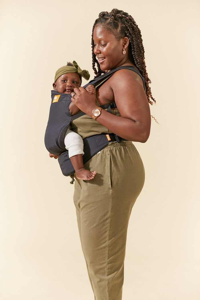 Mama nosi dziecko w lekkim nosidełku Tula Lite ze zintegrowaną nerką