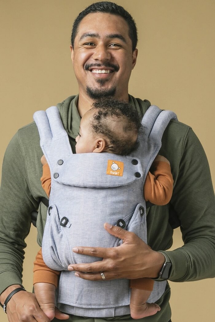 Tata nosi małe dziecko w nosidełku Tula Linen Explore Rain