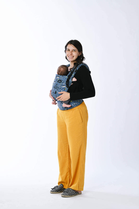 Mama nosi malutkie dziecko w nosidełku Tula Free-to-Grow w pozycji serce do serca.