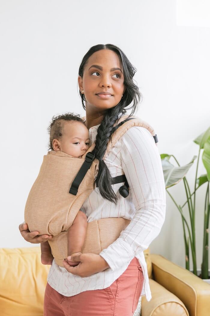 Mama nosi niemowlaka w nosidełku Tula Linen Free-to-Grow Mesa w pozycji przodem do rodzica