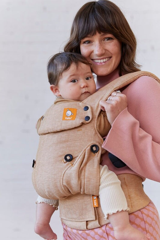 Mama nosi dziecko w nosidełku Tula Linen Explore Mesa w pozycji przodem do rodzica
