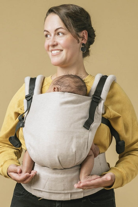 Mama nosi noworodka w nosidełku Tula Linen Free-to-Grow z lnu i czesanej bawełny